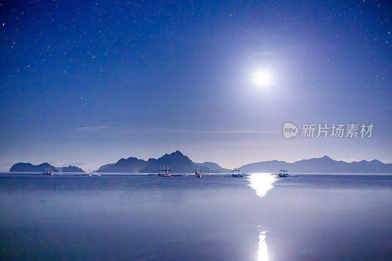 爱妮岛夜景，菲律宾:传统的菲律宾船在天空，大海和山的剪影。