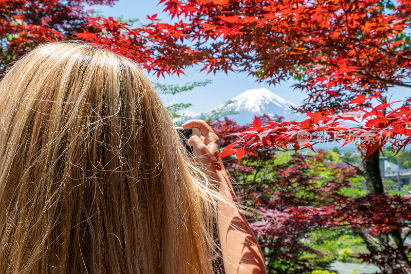 一名女子在日本旅行，她用手机拍了一张照片