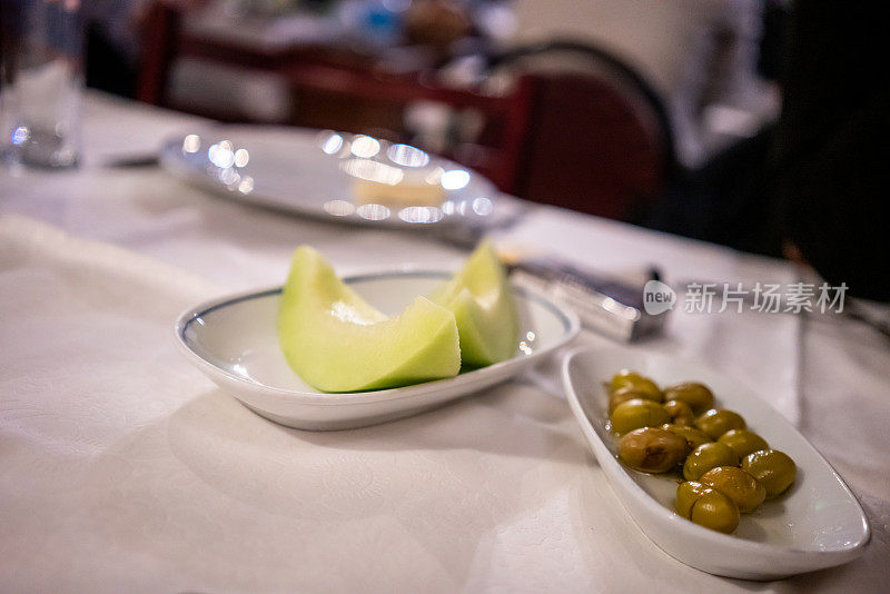 在饭店里，西瓜和橄榄横着摆在桌上