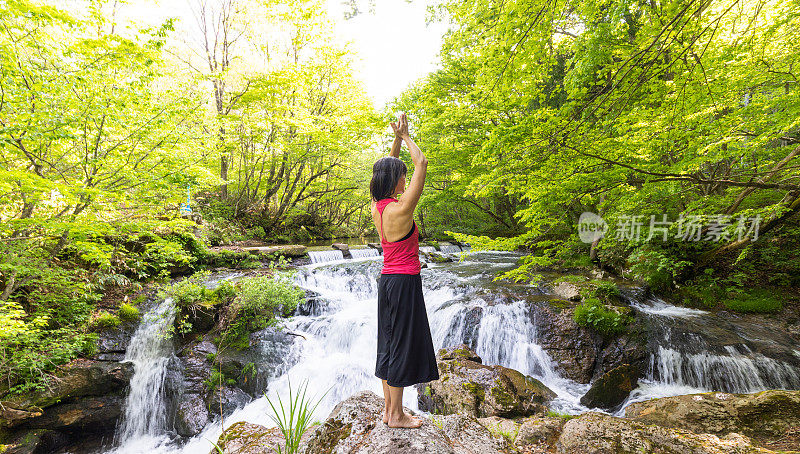 一个女人在瀑布边沉思