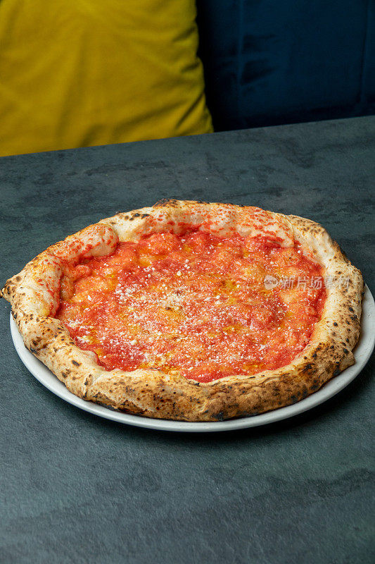 那不勒斯披萨配番茄和磨碎的奶酪，吃披萨店的桌子