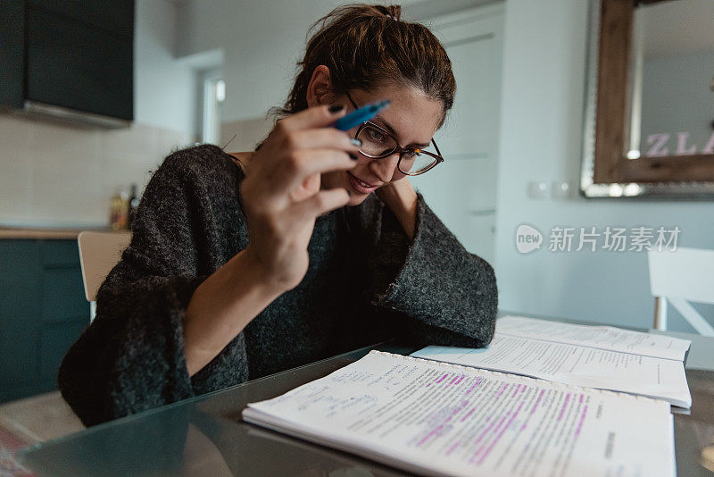 一个可爱的小女孩正在家里准备一场极具挑战性的大学考试。-库存照片