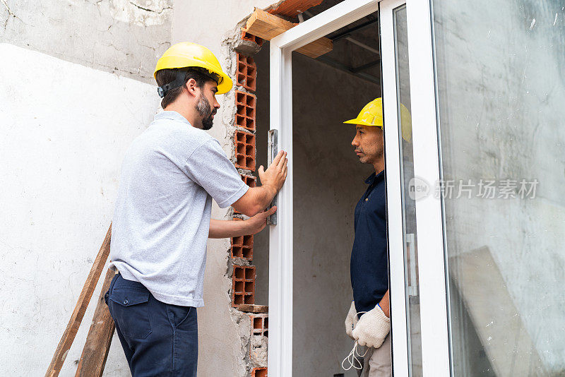 建筑工人在建筑工地安装窗户