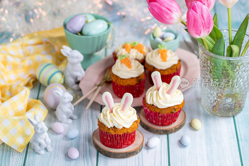 复活节纸杯蛋糕，奶油芝士糖霜，胡萝卜和兔子耳朵装饰。