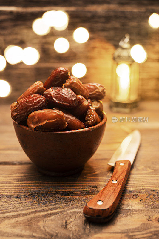 可口的干枣，水果和刀与阿拉伯光背景的形象。斋月穆斯林斋月的节日。