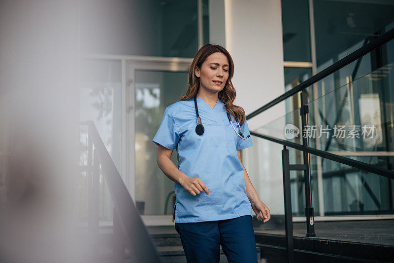 图为一位女医生从医院的楼梯间走下来。