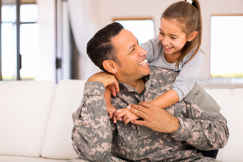 小女孩拥抱她的军人父亲