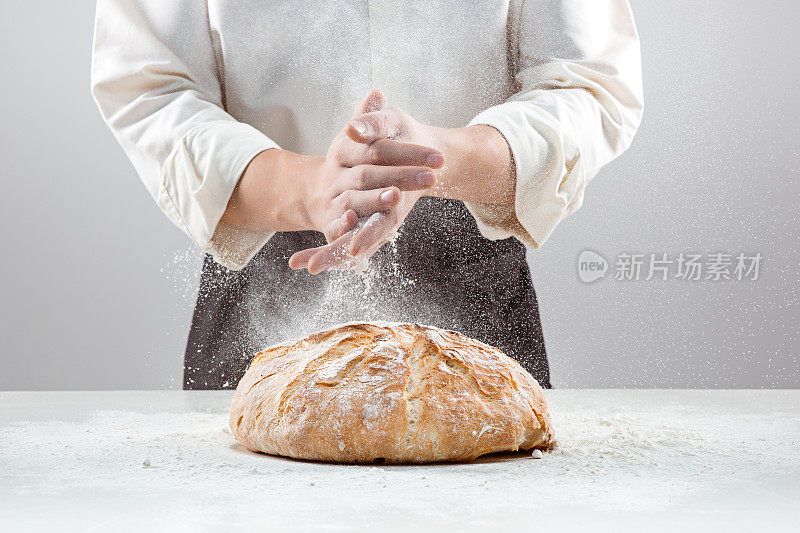 男子的手在面粉和乡村有机面包