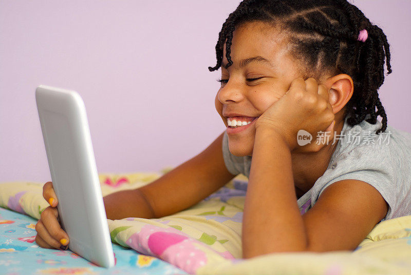 微笑的小女孩拿着平板电脑
