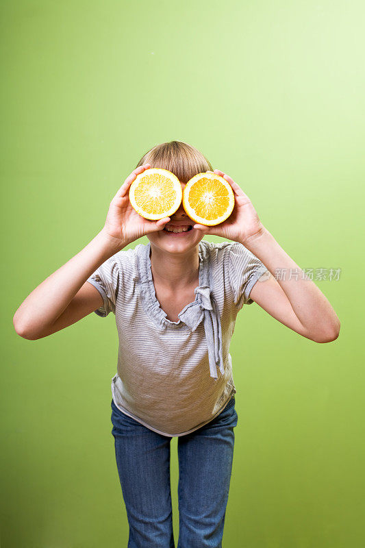 小女孩在玩橘子