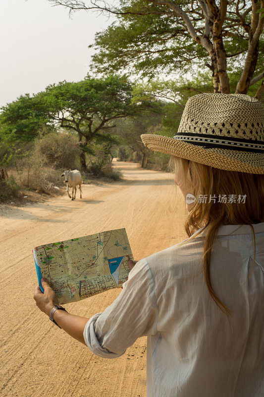 在沙漠里看地图的旅行女人