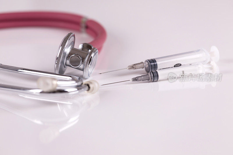 医疗保健系列:听诊器和注射器的白色背景