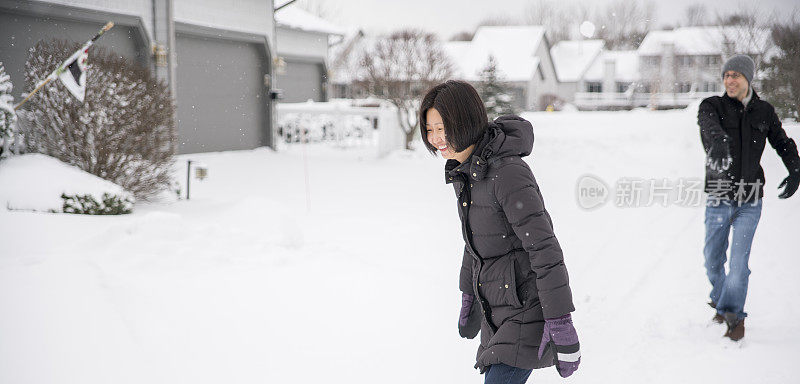 多民族的夫妇在户外的雪下玩耍