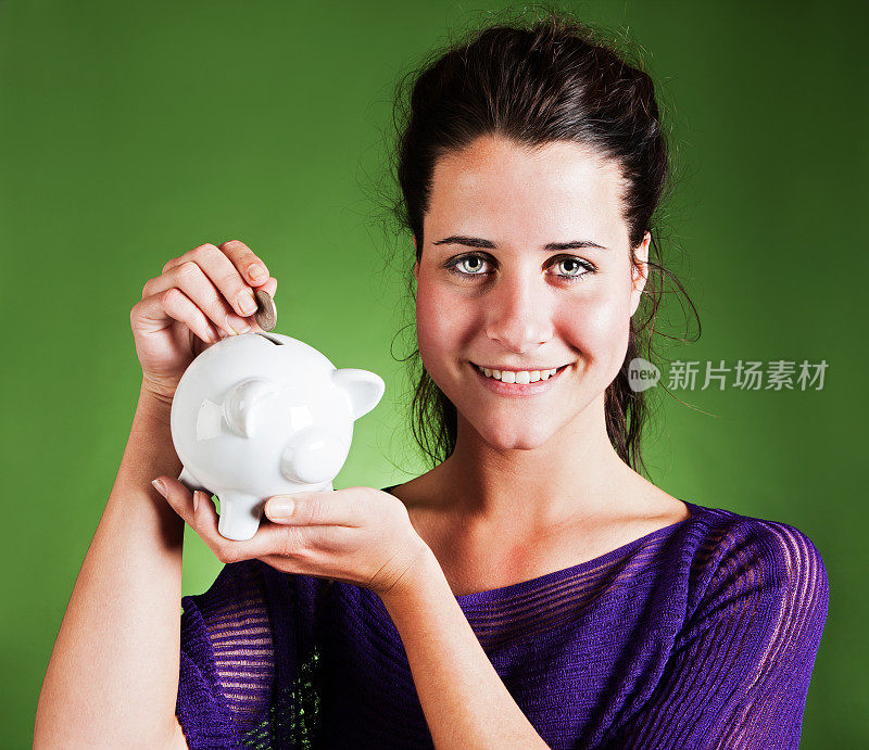 微笑的黑发女子向储蓄罐投硬币:存钱是令人满意的!