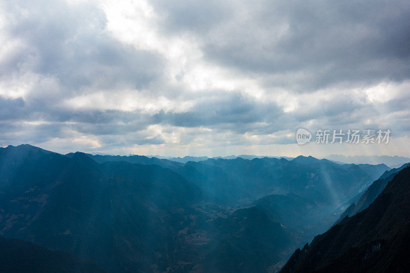 阳光透过云层在山上