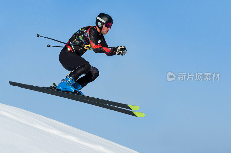 在高山滑雪比赛中在跳远的职业男子滑雪者