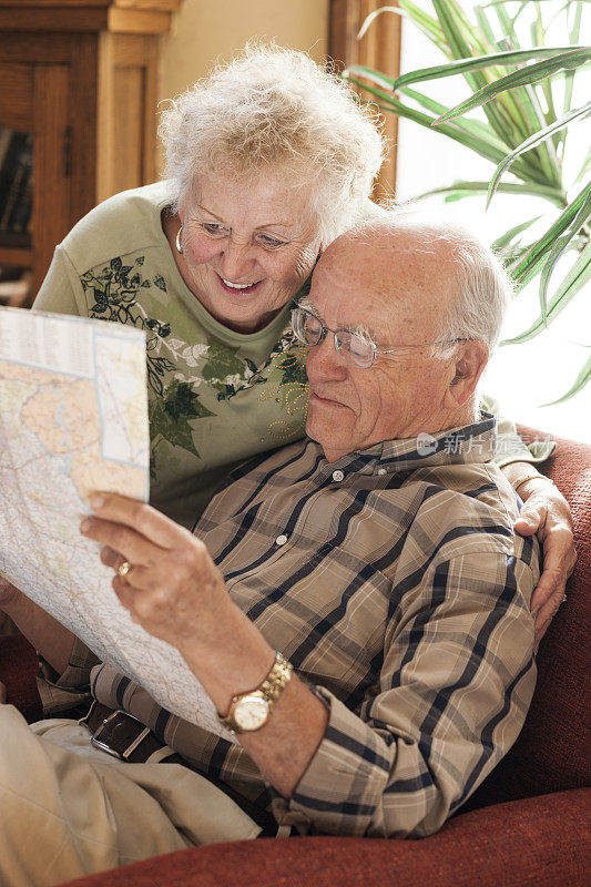 一对老年夫妇带着地图计划一次旅行