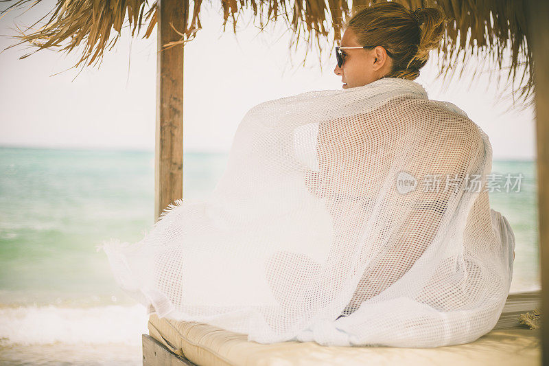 年轻的女子在夏天望着天空和大海