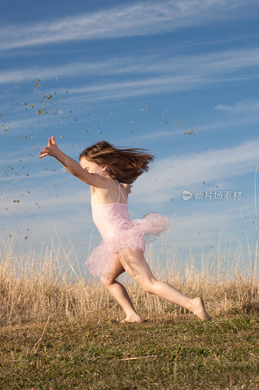 小芭蕾舞女演员一边跳舞一边扔草