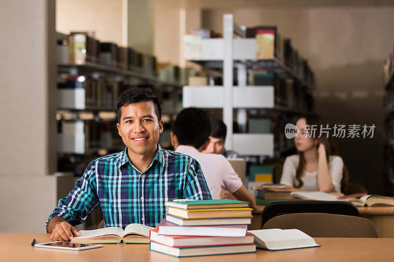 拉丁大学生在图书馆里对着镜头微笑
