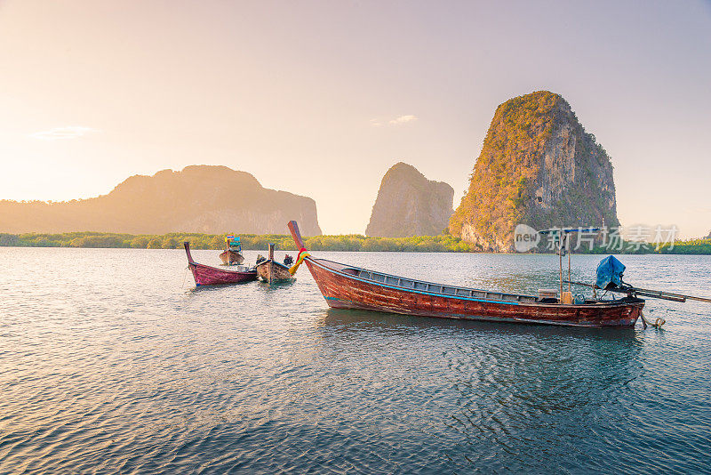 美丽的日落在热带海洋与长尾船在泰国南部