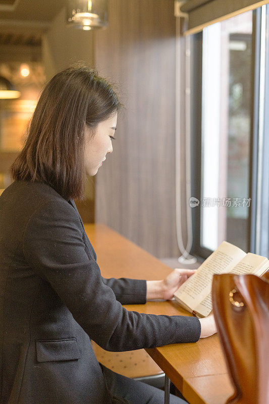 在咖啡馆看书的女人