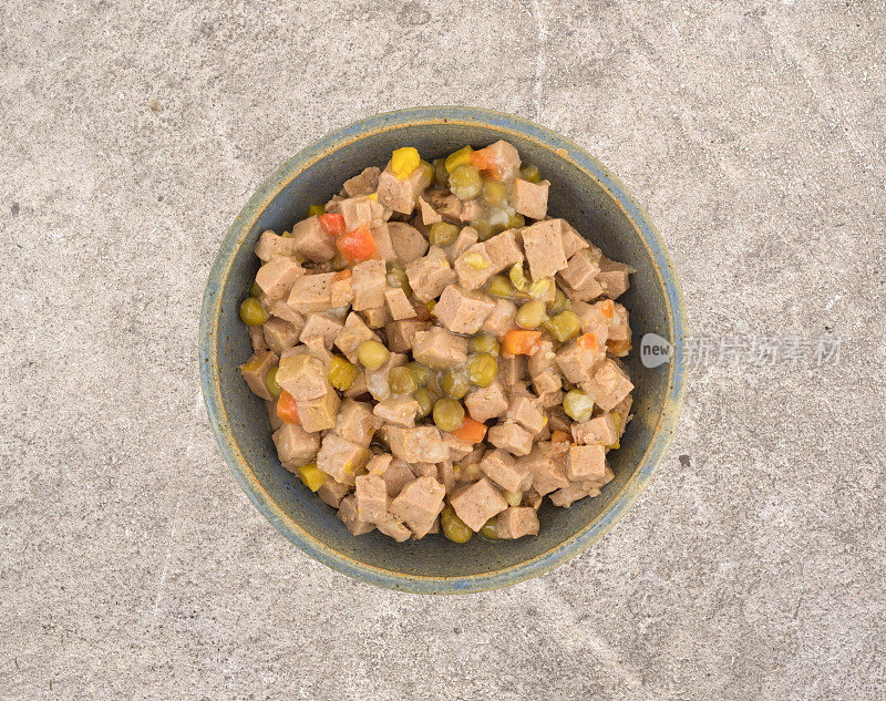 水泥地板上的陶瓷碗，盛着羊羔肉和狗粮