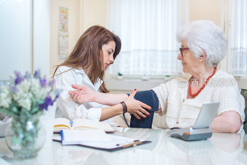护士把血压计放在老妇人的手上。