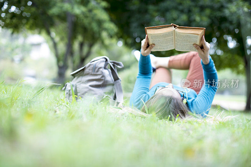 年轻女子在户外读书
