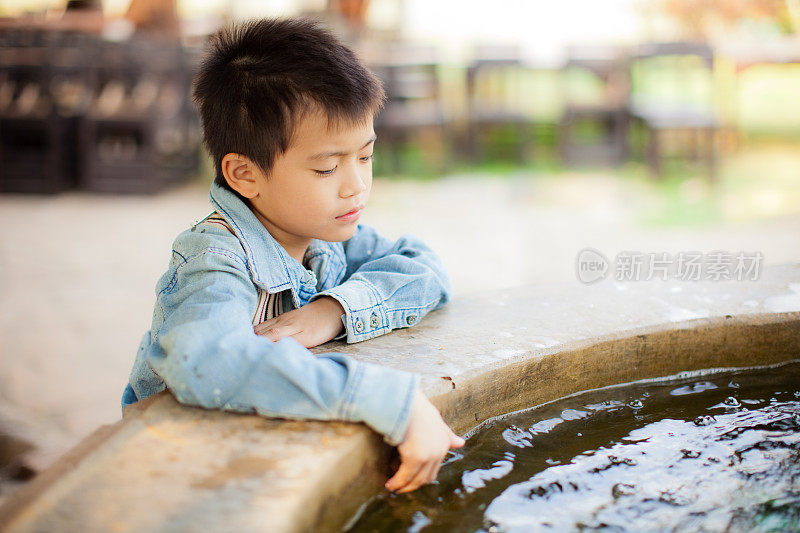 一个男孩往水里看