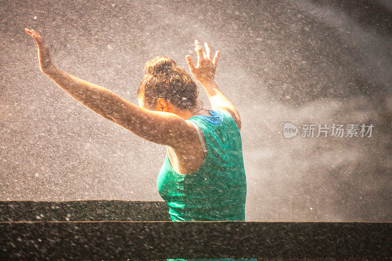 年轻女子在水花中挥挥手落下水花