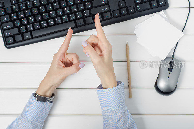 女性的手在显示器上显示了一张纸条，上面写着电脑键盘鼠标