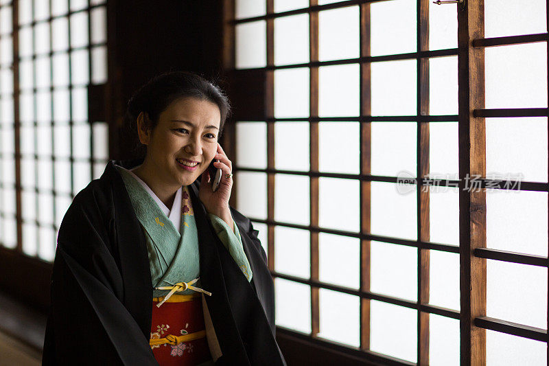 和服女士在百库曼本Chionji寺拿着电话