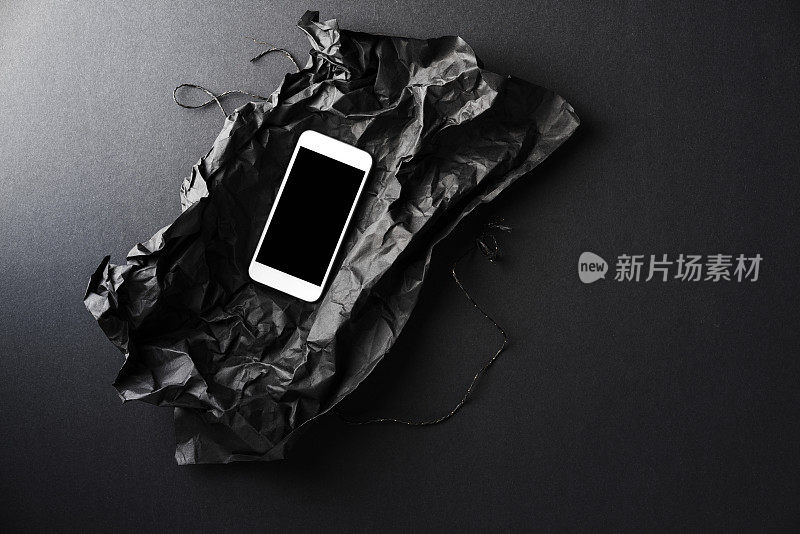黑色包装纸的白色智能手机