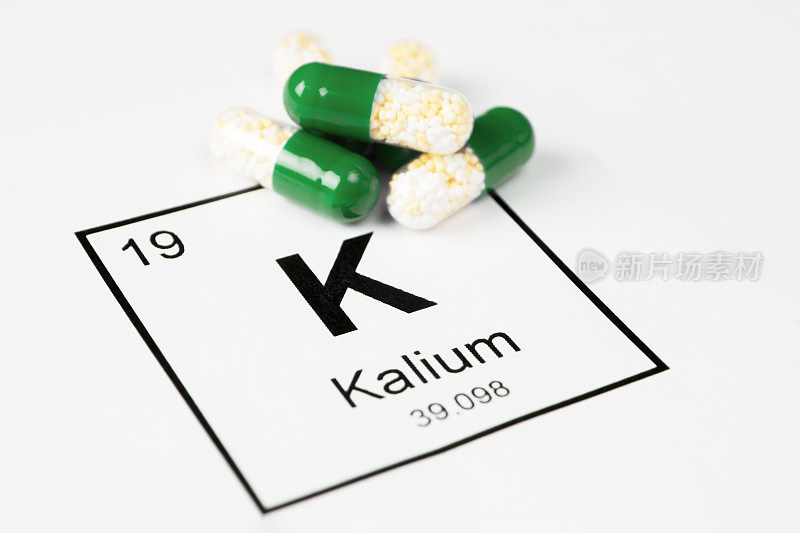 含有矿物质K(钾)的绿色药丸，白色背景上有化学表上的铭文