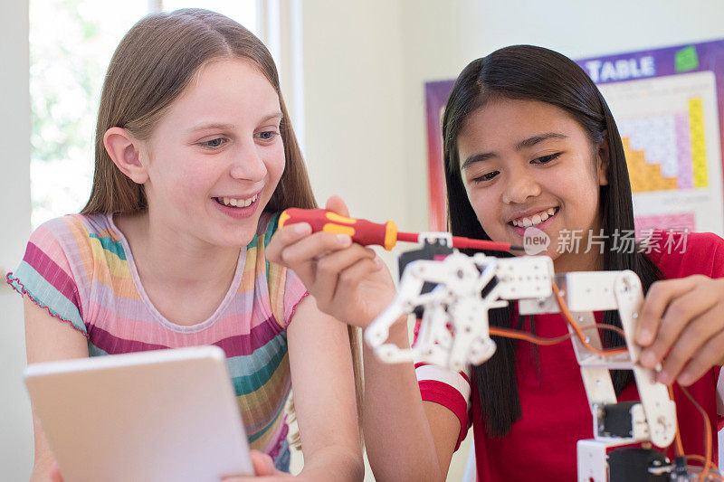 两个女学生在科学课上学习机器人