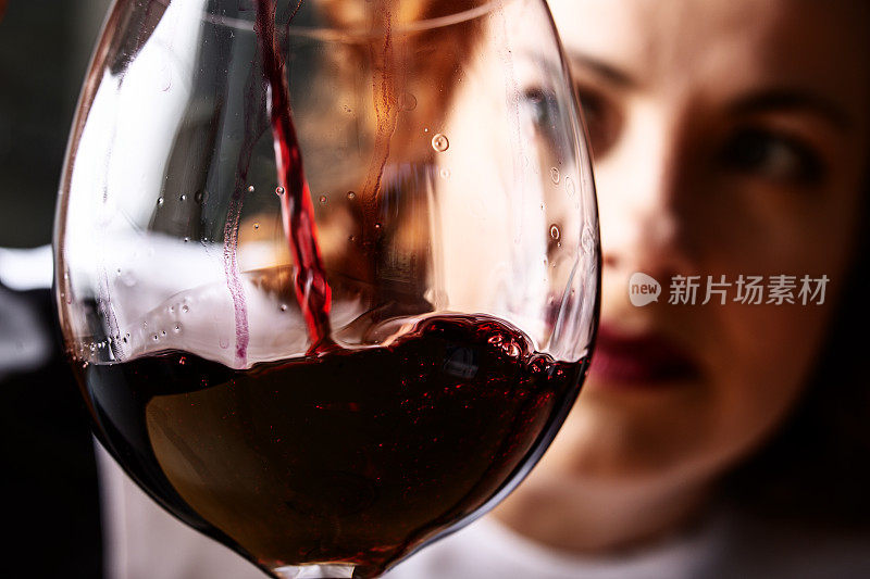 女人把红酒倒进酒杯里