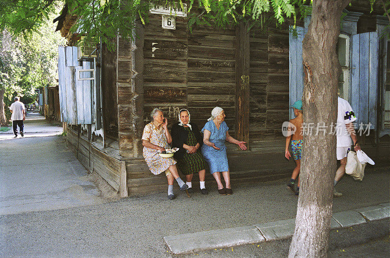 在俄罗斯阿斯特拉罕市老城区，一名老年妇女坐在一间木屋上