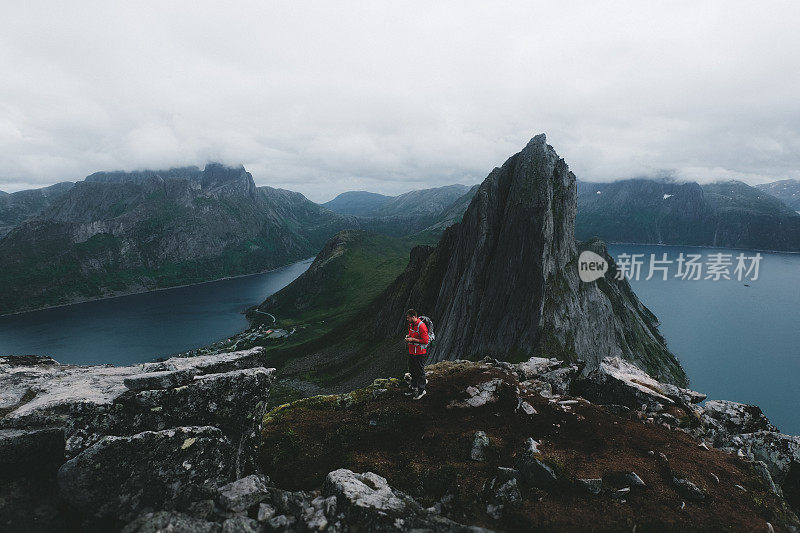 一名男子带着狗和背包徒步旅行到挪威的塞格拉山