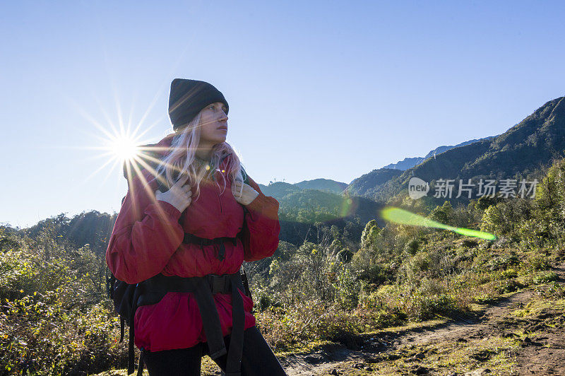 年轻女子在山间小径徒步旅行