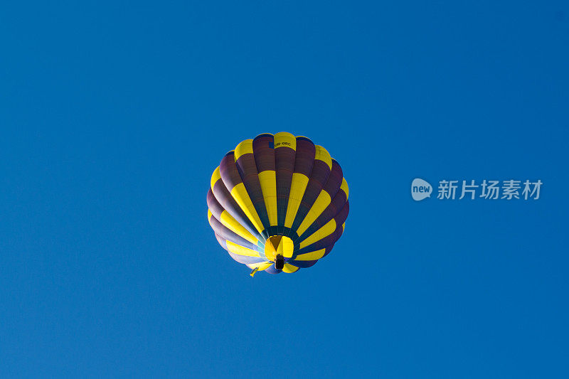 黄色气球映衬着蓝色的天空。航空器。篮子里的人。乐趣。夏天娱乐。浪漫的冒险。