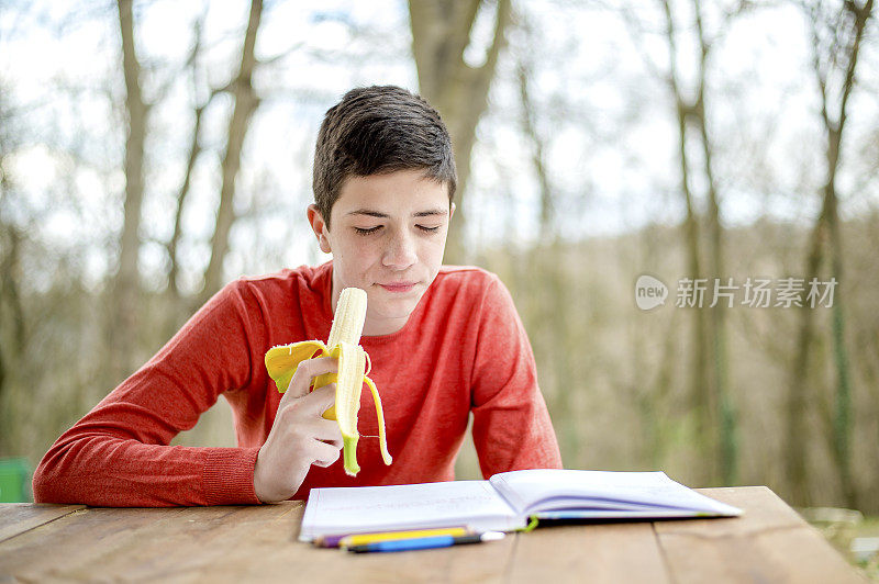 一个在城市公园里学习的少年。吃健康零食的时间到了