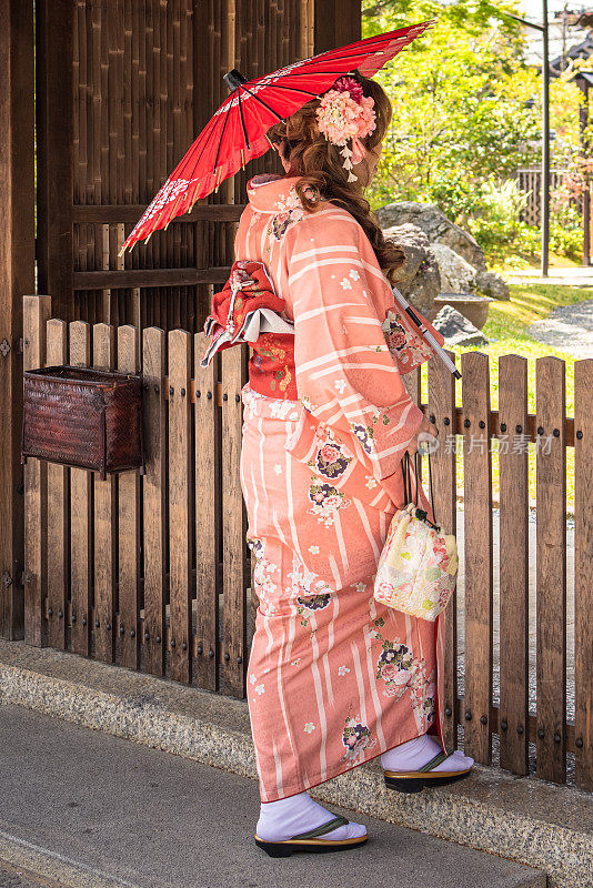 美丽的亚洲妇女穿着和服与阳伞在京都，日本