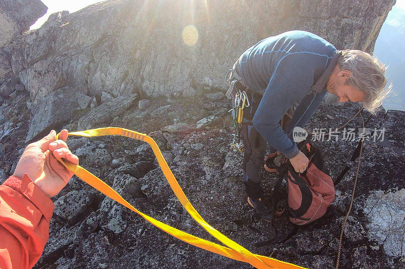 一名登山者向困境中的同伴伸出援手