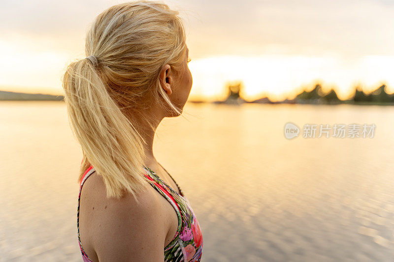 年轻女子在海岸线看日落