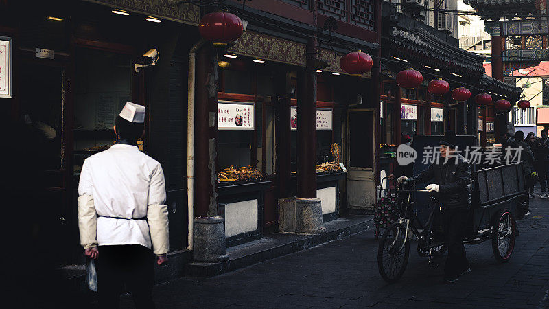 中国北京，王府井大街，一位厨师站在他的小吃摊前