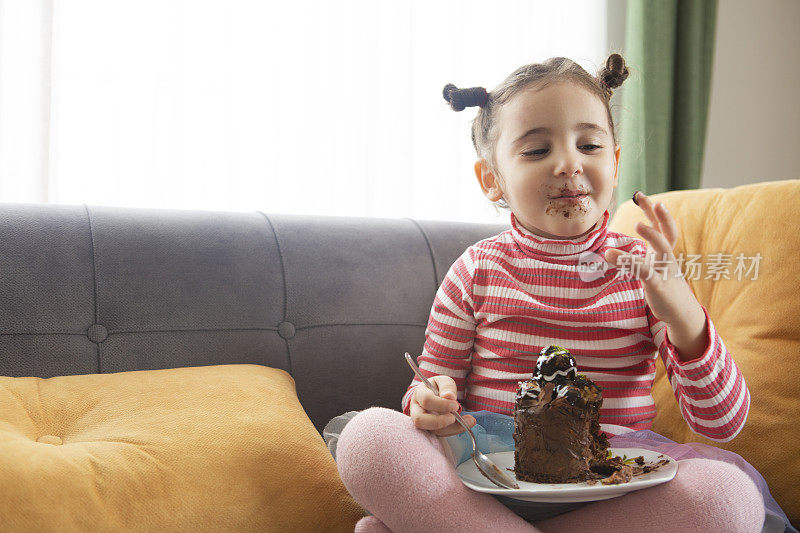 可爱的小女孩在吃巧克力蛋糕