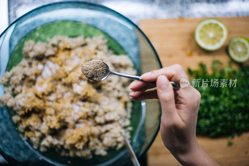 女人用茶匙加入黑胡椒