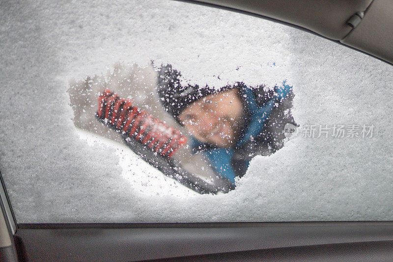 刮着车窗外的冰雪，男人正看着车窗外