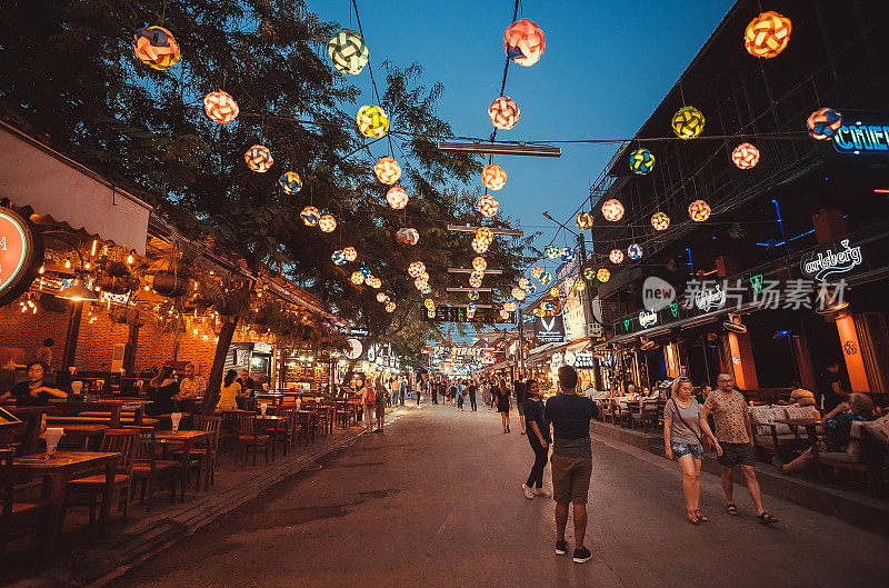 人们在亚洲城市的主要街道上享受快乐和晚餐，有酒吧，咖啡馆和餐馆